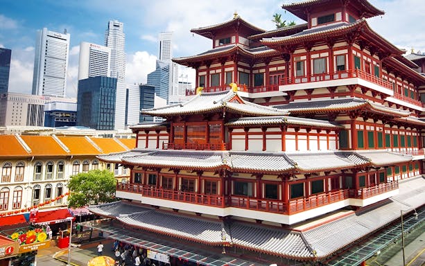 Buddha Tooth Relic Temple in Chinatown, Singapore with city skyline in the background.