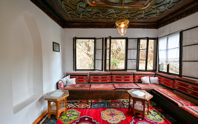 Inside seating area of Blagaj Dervish Tekke, Bosnia Herzegovina, with traditional decor.