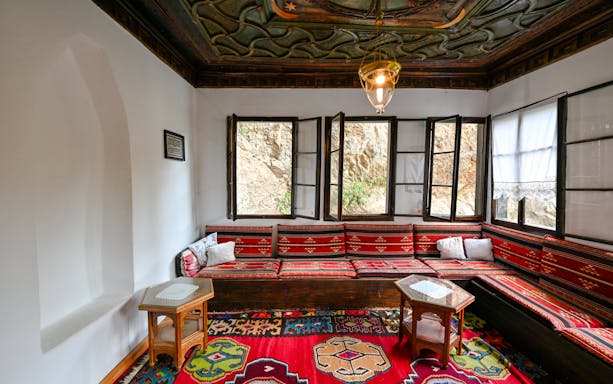 Inside seating area of Blagaj Dervish Tekke, Bosnia Herzegovina, with traditional decor.