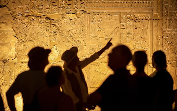 Guide explaining hieroglyphs to tourists at Saladin Citadel, Cairo.