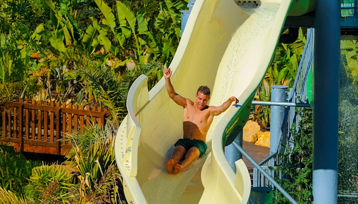 Tourist descending waterslide at Zoomarine Algarve water park, Portugal.