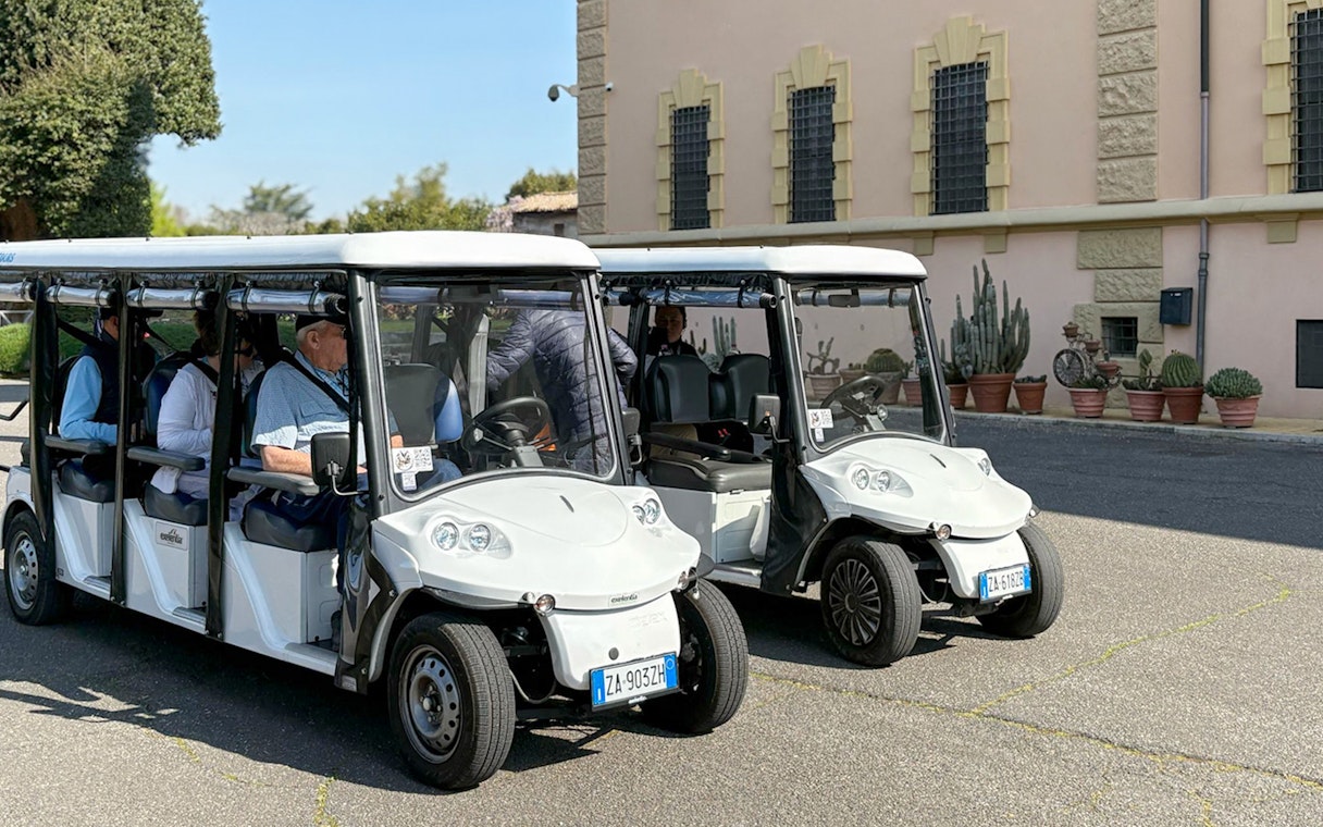 Golf carts parked outside a historic building in Rome during a tour.