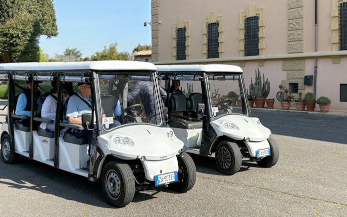 Golf carts parked outside a historic building in Rome during a tour.