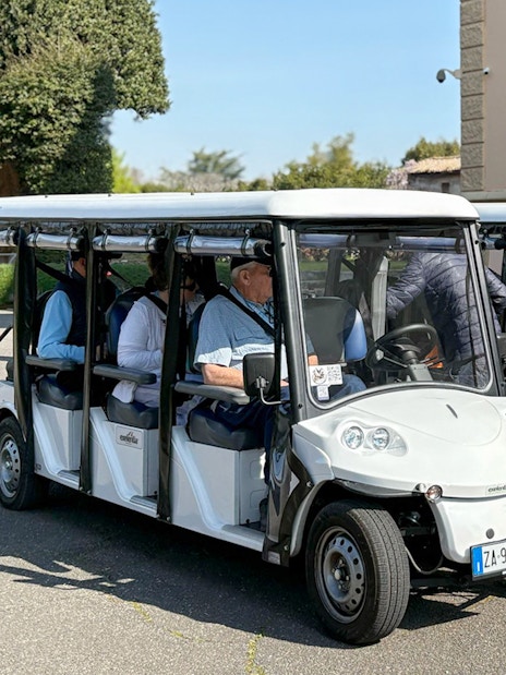Golf carts parked outside a historic building in Rome during a tour.