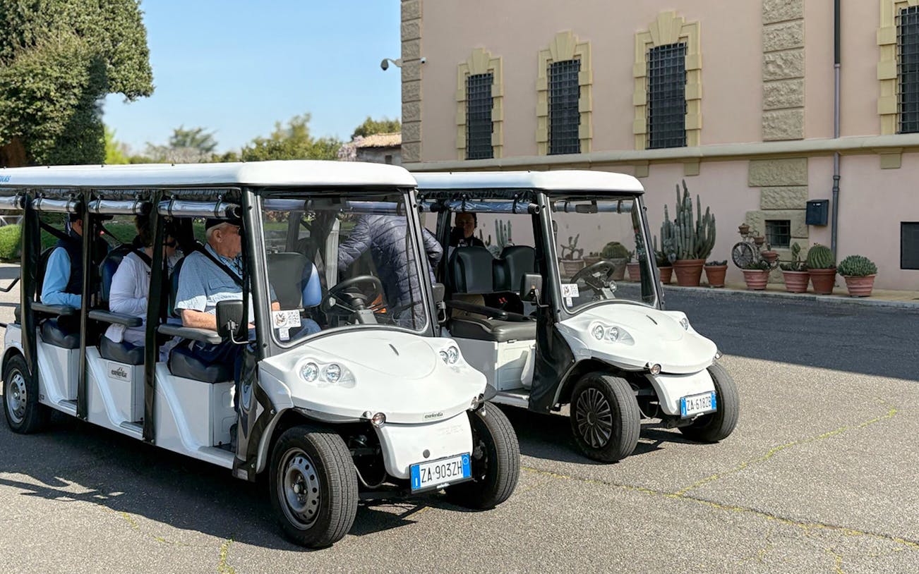 Golf carts parked outside a historic building in Rome during a tour.