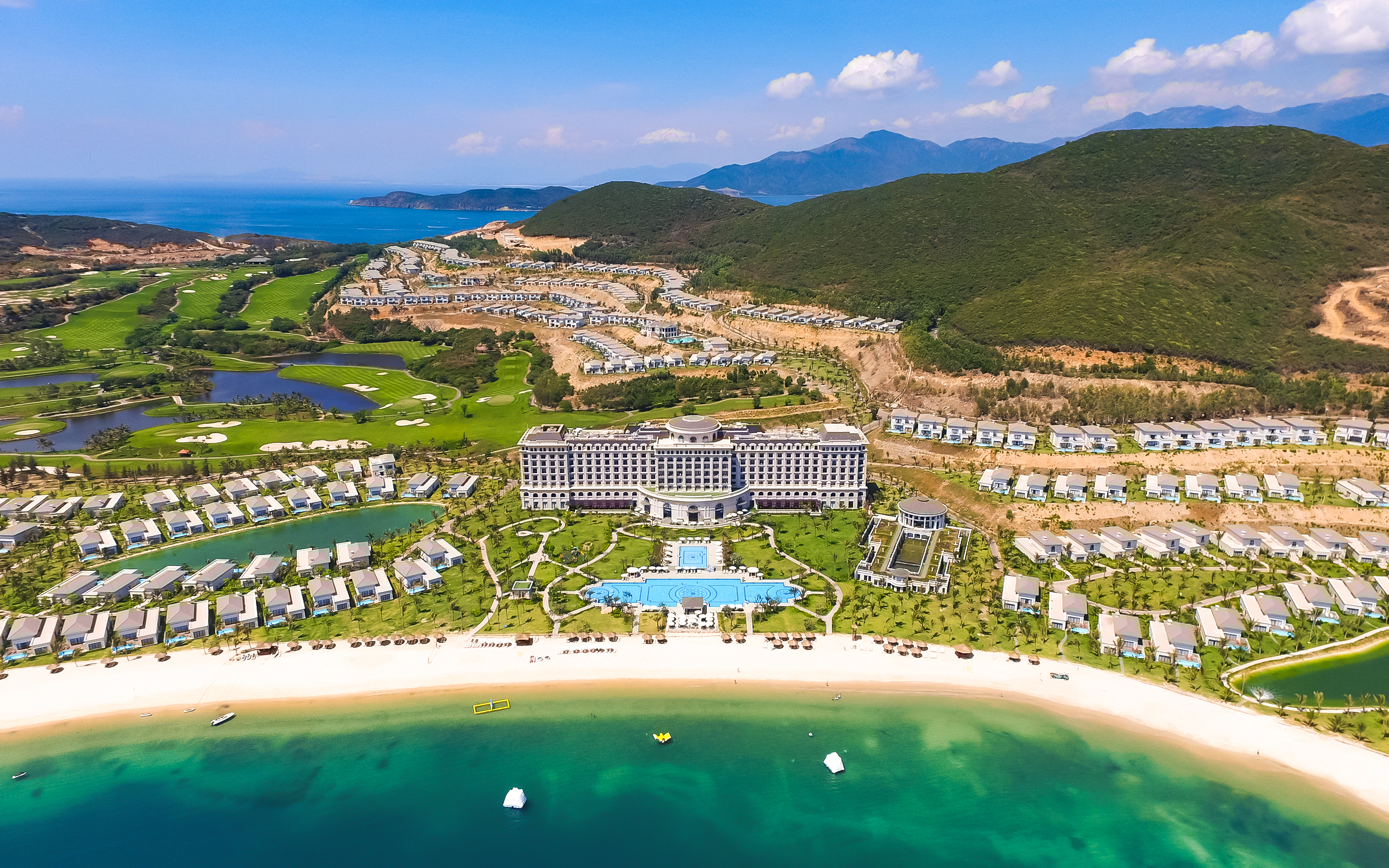 Aerial view of Vinpearl Resort in Nha Trang with beach, villas, and lush greenery.