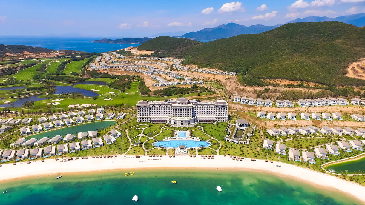 Aerial view of Vinpearl Resort in Nha Trang with beach, villas, and lush greenery.