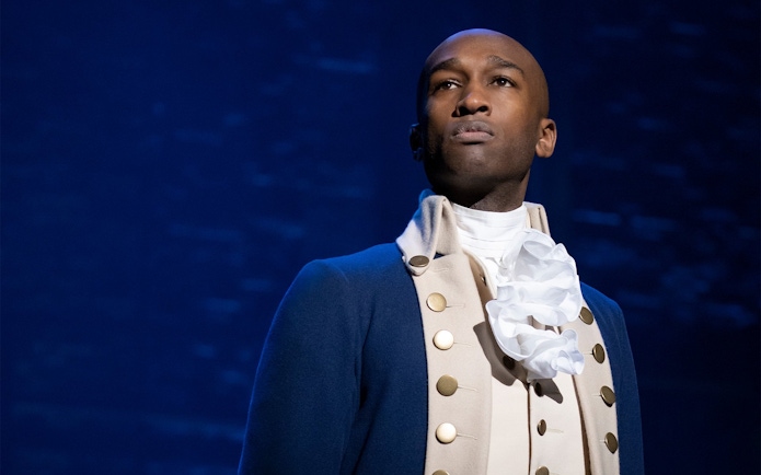 Performer in historical costume from the musical Hamilton.