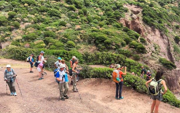 Group of hikers on a trail during a 4-hour guided trek of Faraglioni from Nebida.
