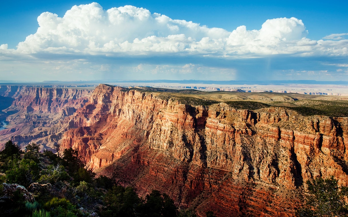 North Grand Canyon cliffs under a blue sky, view from helicopter tour.