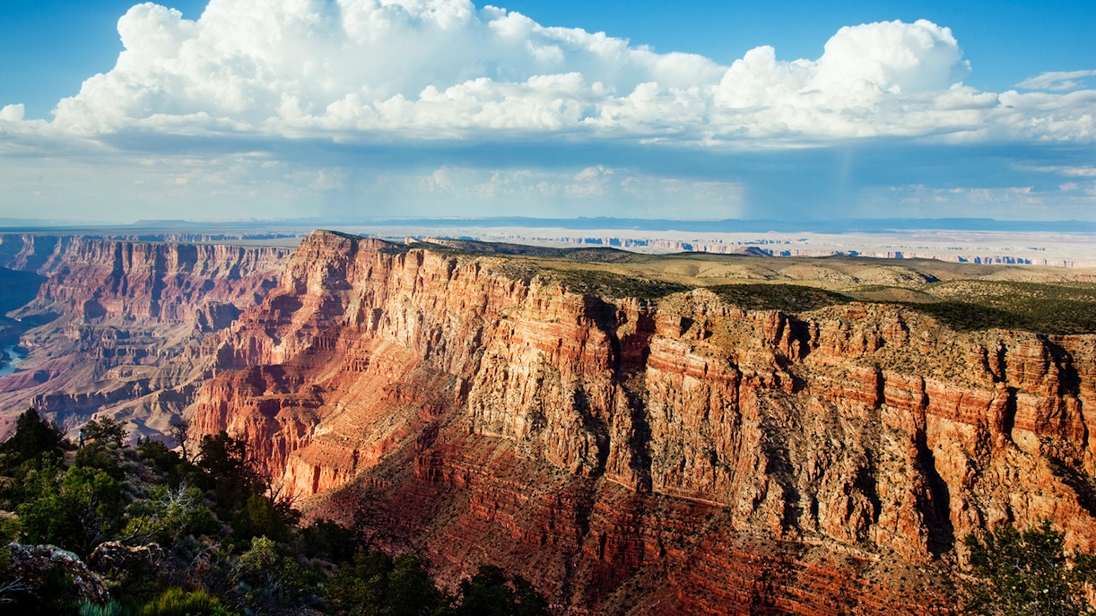 North Grand Canyon cliffs under a blue sky, view from helicopter tour.