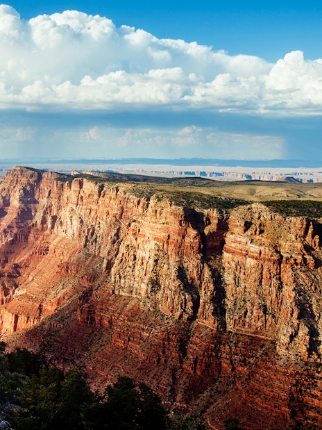 North Grand Canyon cliffs under a blue sky, view from helicopter tour.