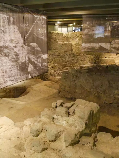 Ancient stone ruins in the Paris Archaeological Crypt with historical displays.