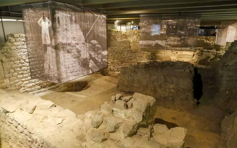 Ancient stone ruins in the Paris Archaeological Crypt with historical displays.