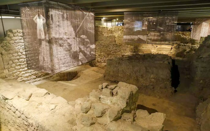 Ancient stone ruins in the Paris Archaeological Crypt with historical displays.