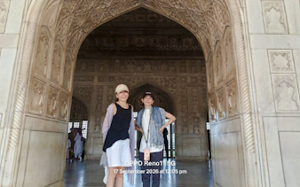 Visitors inside the intricately carved marble archway of the Taj Mahal, Agra.