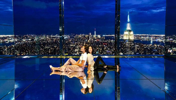 Guests enjoying night views at Summit One Vanderbilt, New York City skyline in the background.