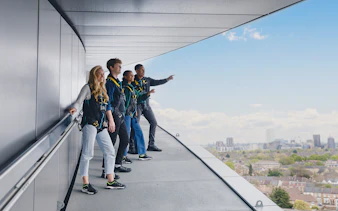 Participants on the Dare Skywalk overlooking cityscape.