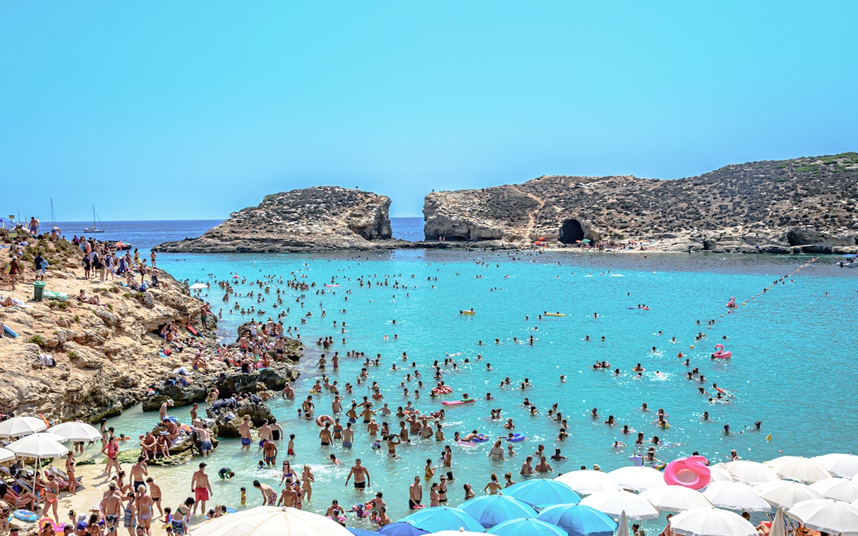 Visitors swimming and relaxing at the Blue Lagoon, Malta.