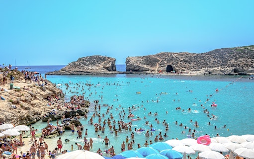 Visitors swimming and relaxing at the Blue Lagoon, Malta.