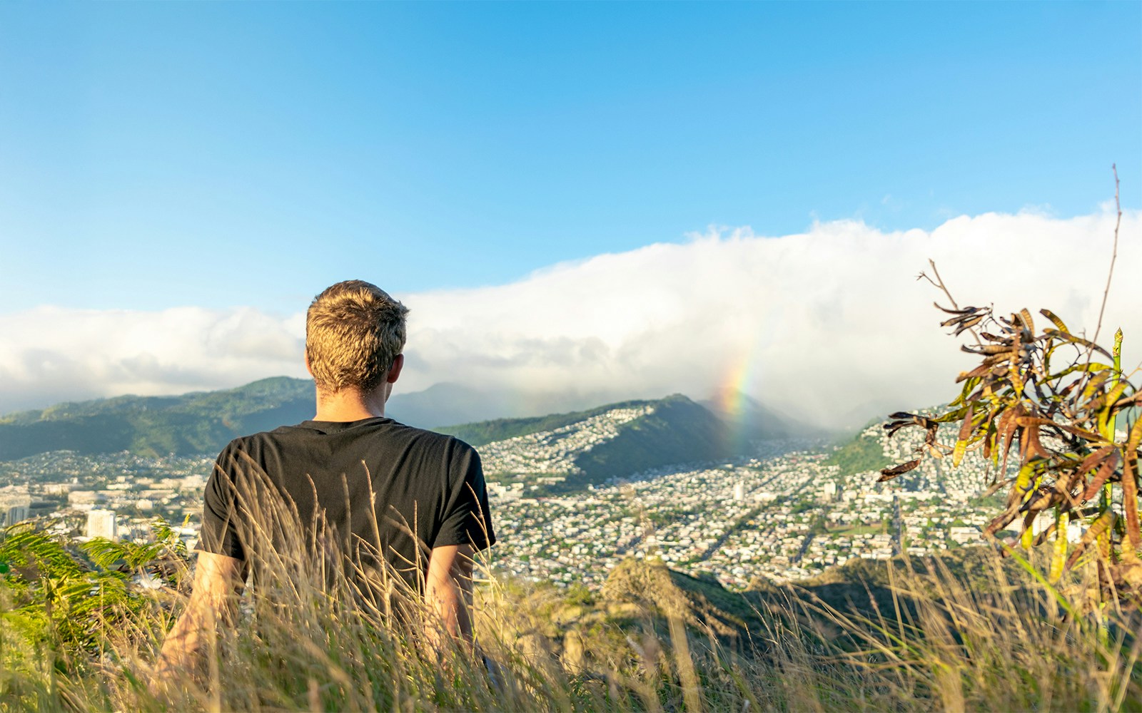 Young male hiker sitting on the summit of Diamond Head Crater in Honolulu on the Island of Oahu