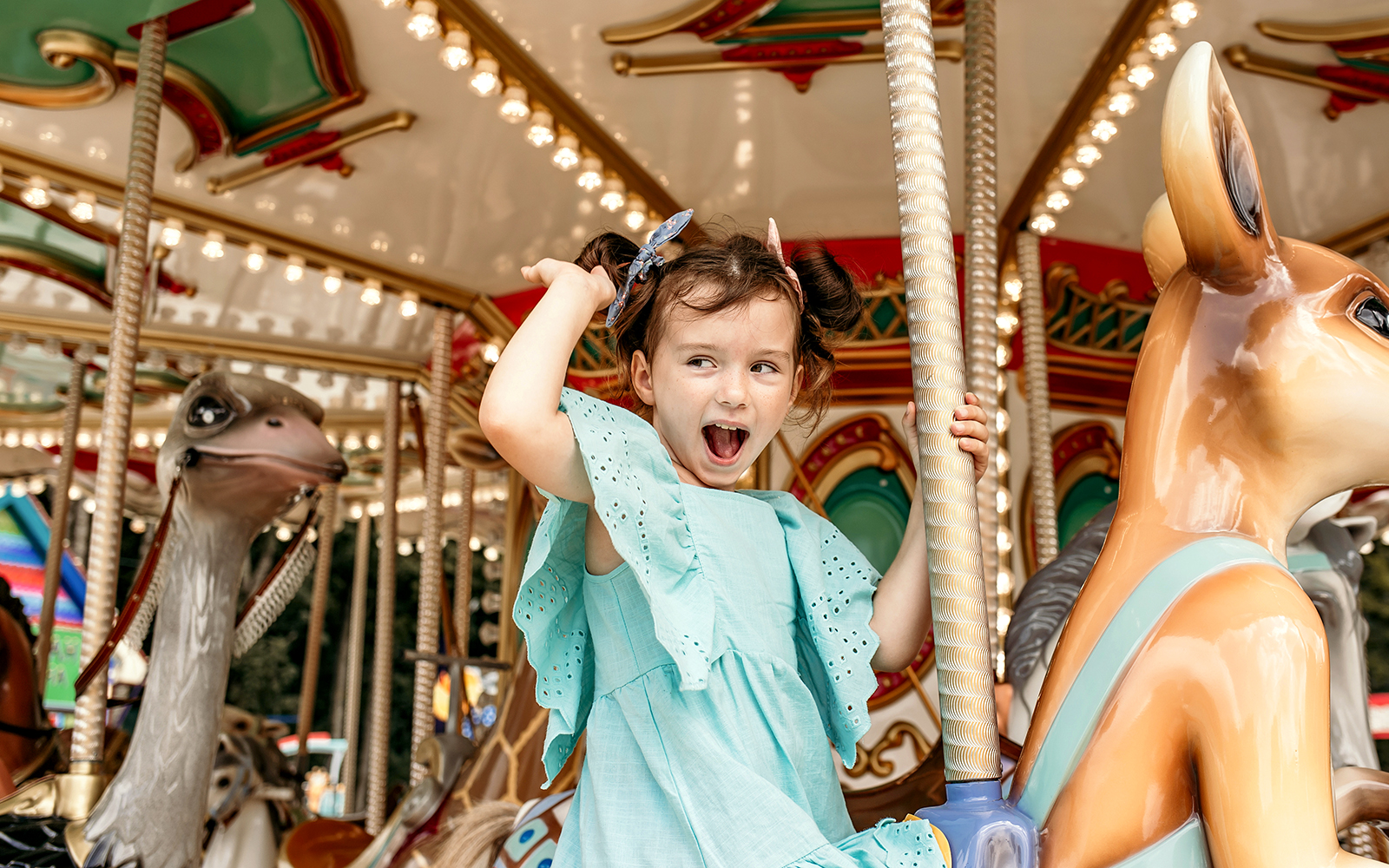 Child enjoying a ride on a cartoon-themed carousel.