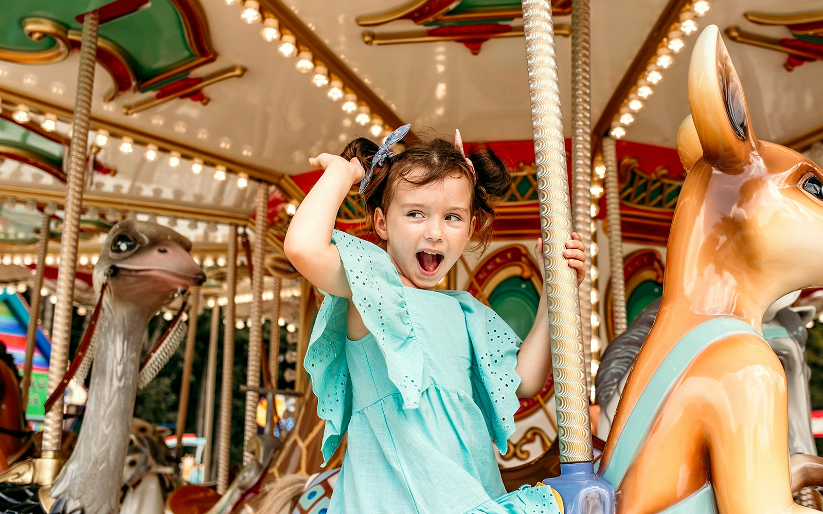 Child enjoying a ride on a cartoon-themed carousel.