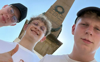 Three people in front of a monument during the Florence Detective Mystery game.