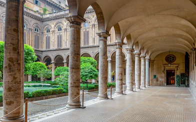 Doria Pamphilj Courtyard with stone columns and lush greenery in Rome.