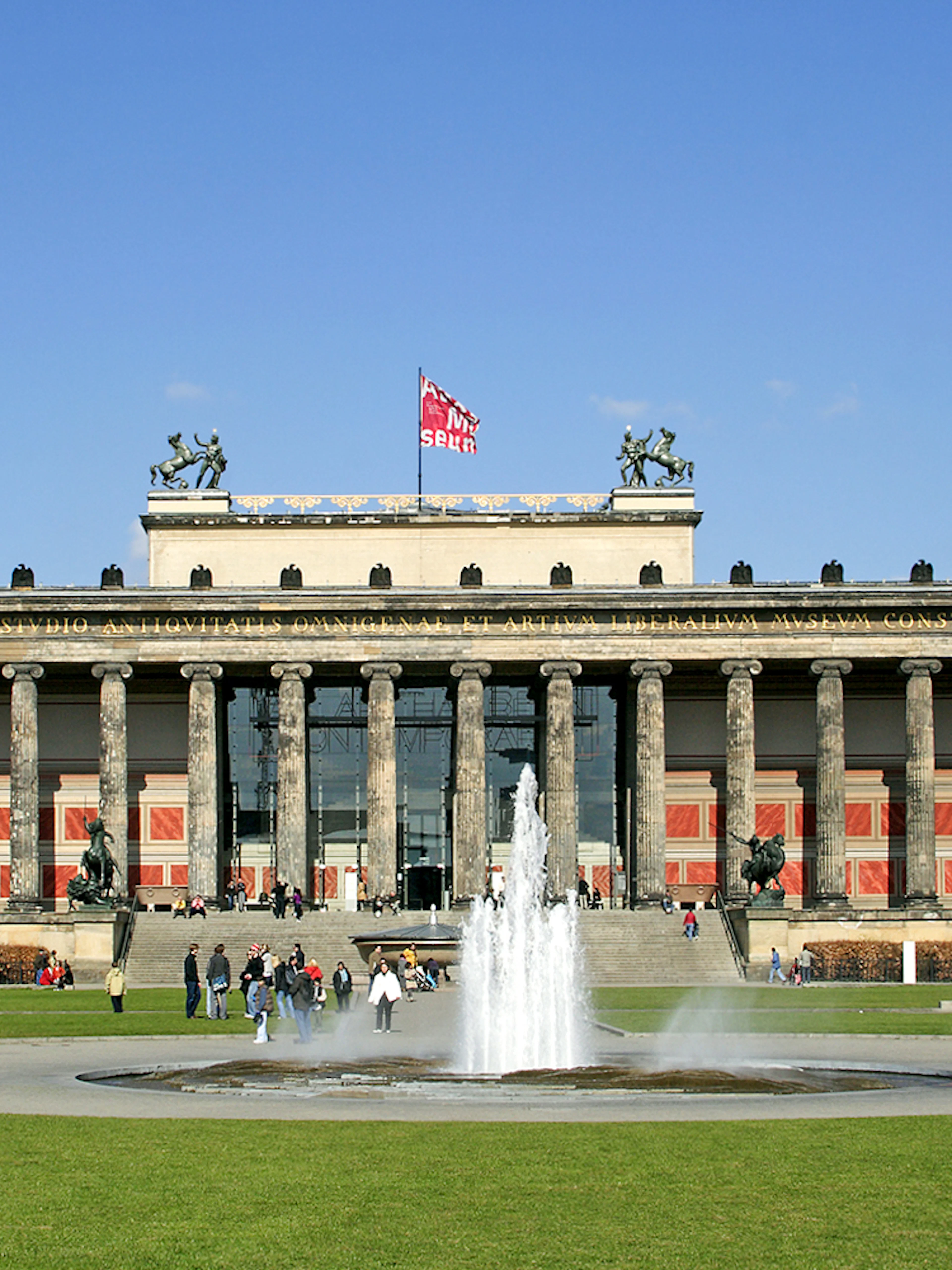 Altes Museum in Berlin with fountain and visitors in the foreground.