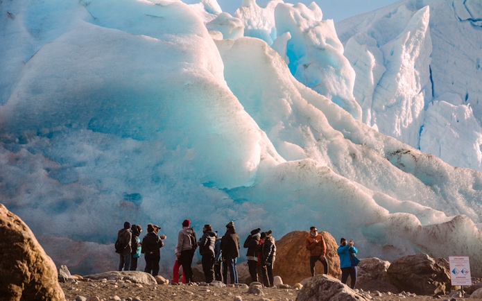 Guests standing near a large glacier on Safari Azul Guided Tour.