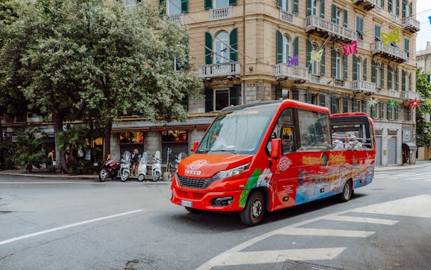 City sightseeing bus driving through urban street with historic buildings.