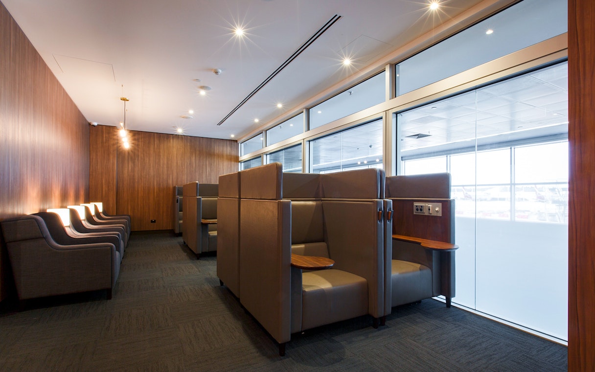 Plaza Premium Lounge seating area with private booths and armchairs.