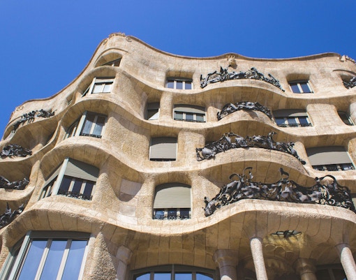 Casa Mila facade detail in Barcelona, showcasing unique stone architecture and iron balconies.