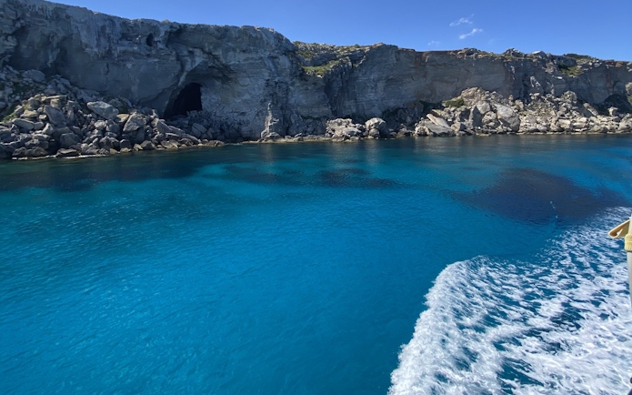 Cruise view of rocky coastline and clear blue waters near Favignana, Sicily.
