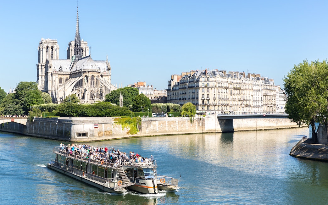 Cruise boat on the Seine River near Notre Dame Cathedral in Paris.