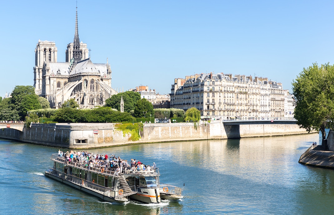 Seine River cruise boat near Notre Dame Cathedral, Paris, with audio guide.