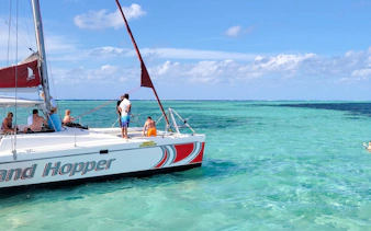 Catamaran sailing to Ile aux Cerfs from Pointe Jerome with passengers enjoying the ocean view.