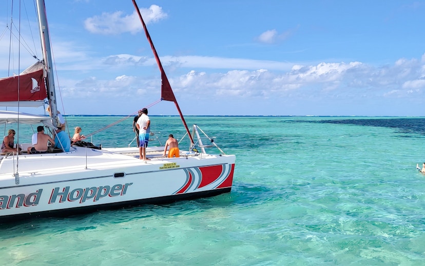 Catamaran sailing to Ile aux Cerfs from Pointe Jerome with passengers enjoying the ocean view.