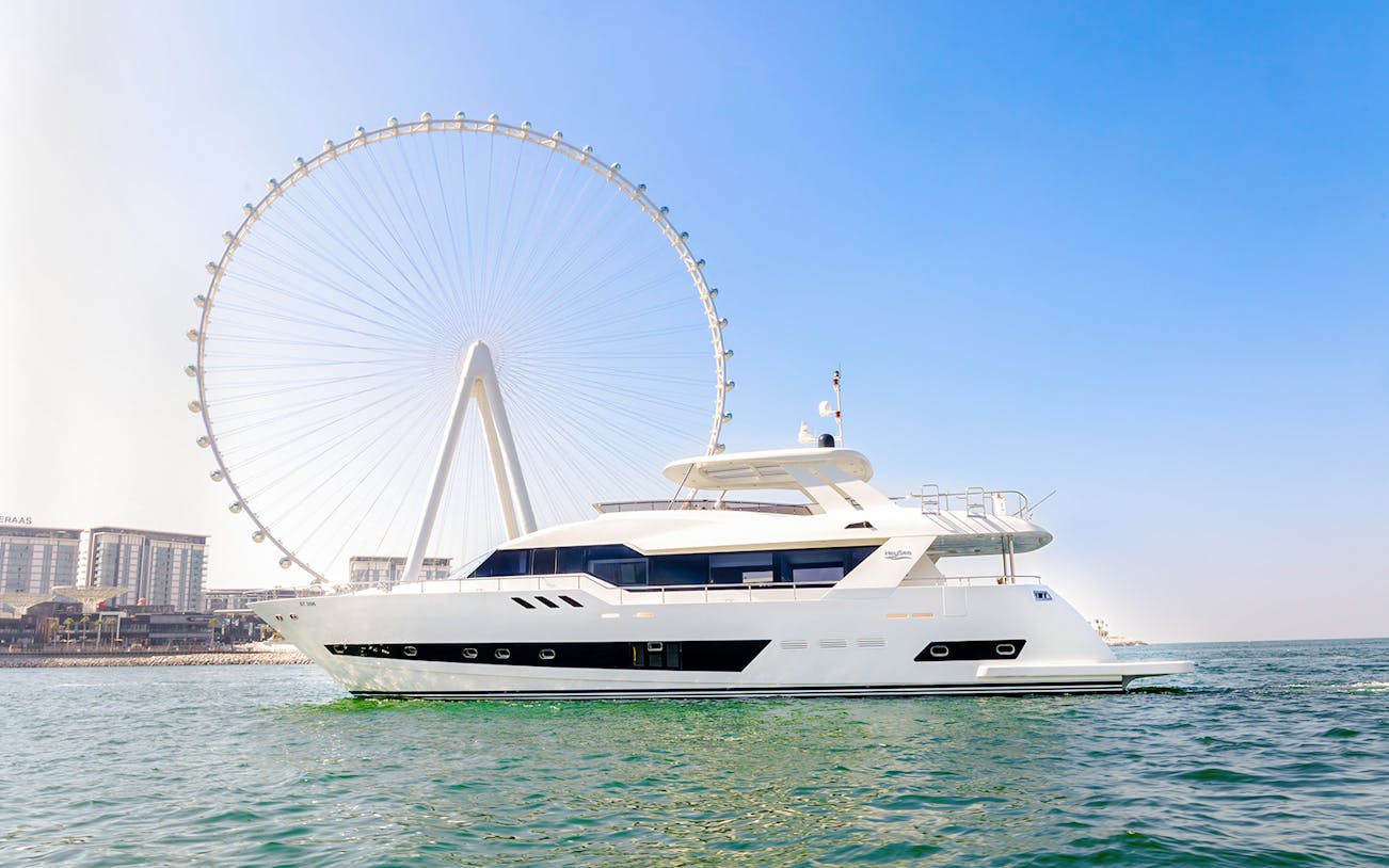 Yacht cruising near Ain Dubai Ferris wheel during sunset tour.