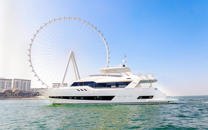 Yacht cruising near Ain Dubai Ferris wheel during sunset tour.