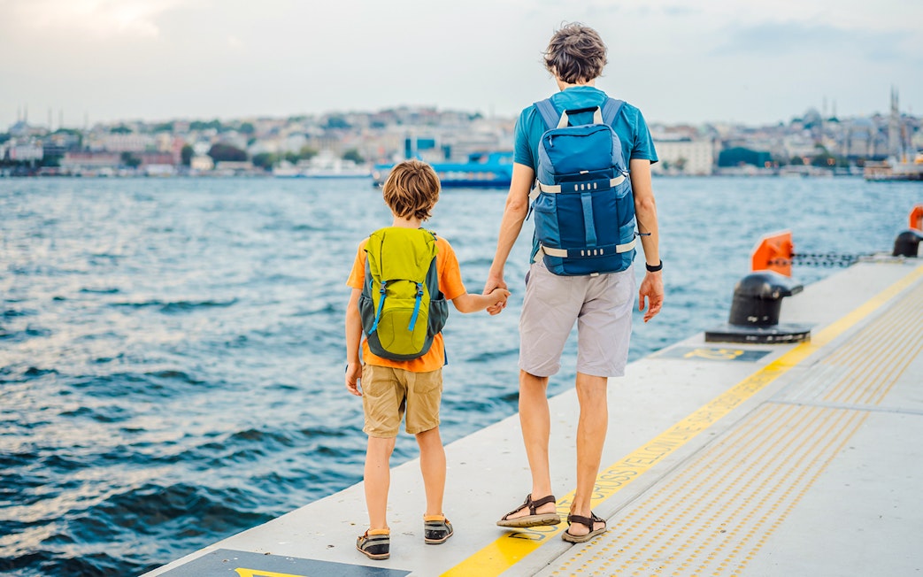 Father and son holding hands at Galataport, Istanbul waterfront.
