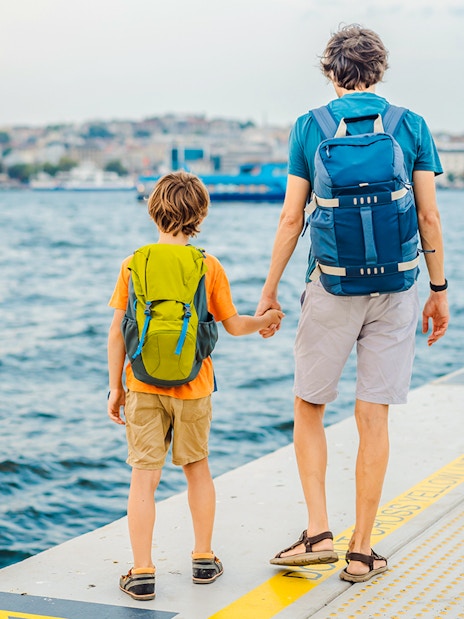 Father and son holding hands at Galataport, Istanbul waterfront.