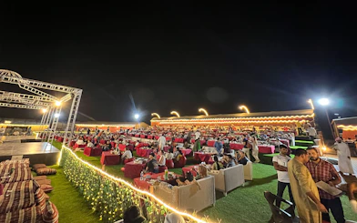 Outdoor dining setup at a Dubai desert safari with guests enjoying BBQ dinner and live shows.