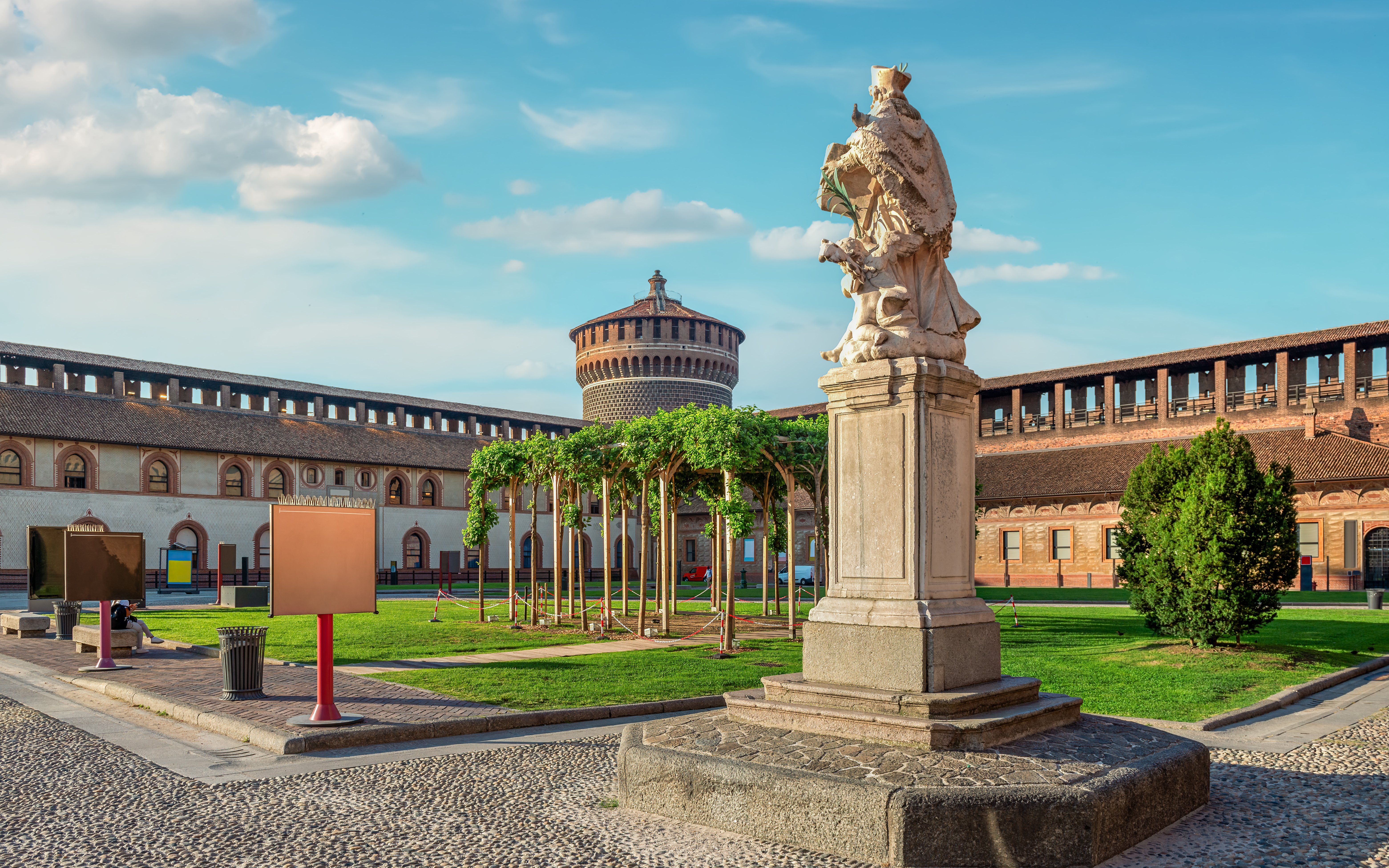 Sforza Castle courtyard with statue and tower in Milan, Italy.