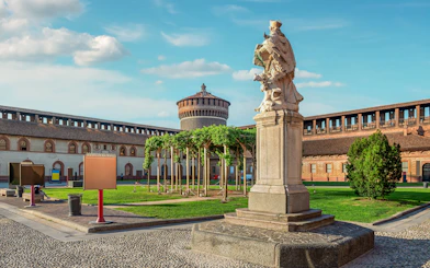 Sforza Castle courtyard with statue and tower in Milan, Italy.