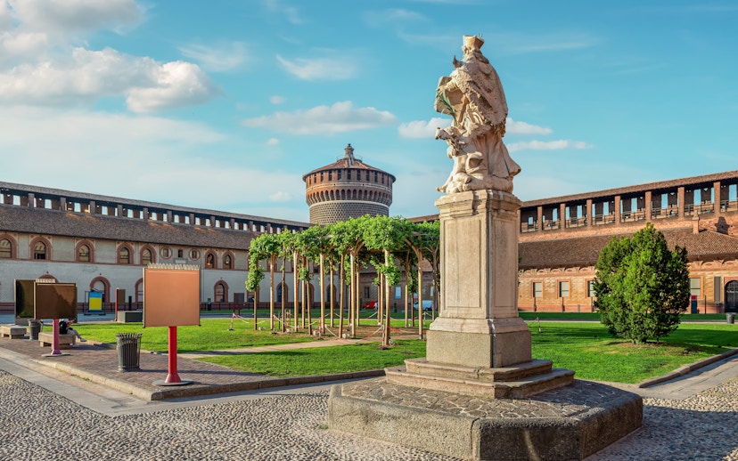 Sforza Castle courtyard with statue and tower in Milan, Italy.