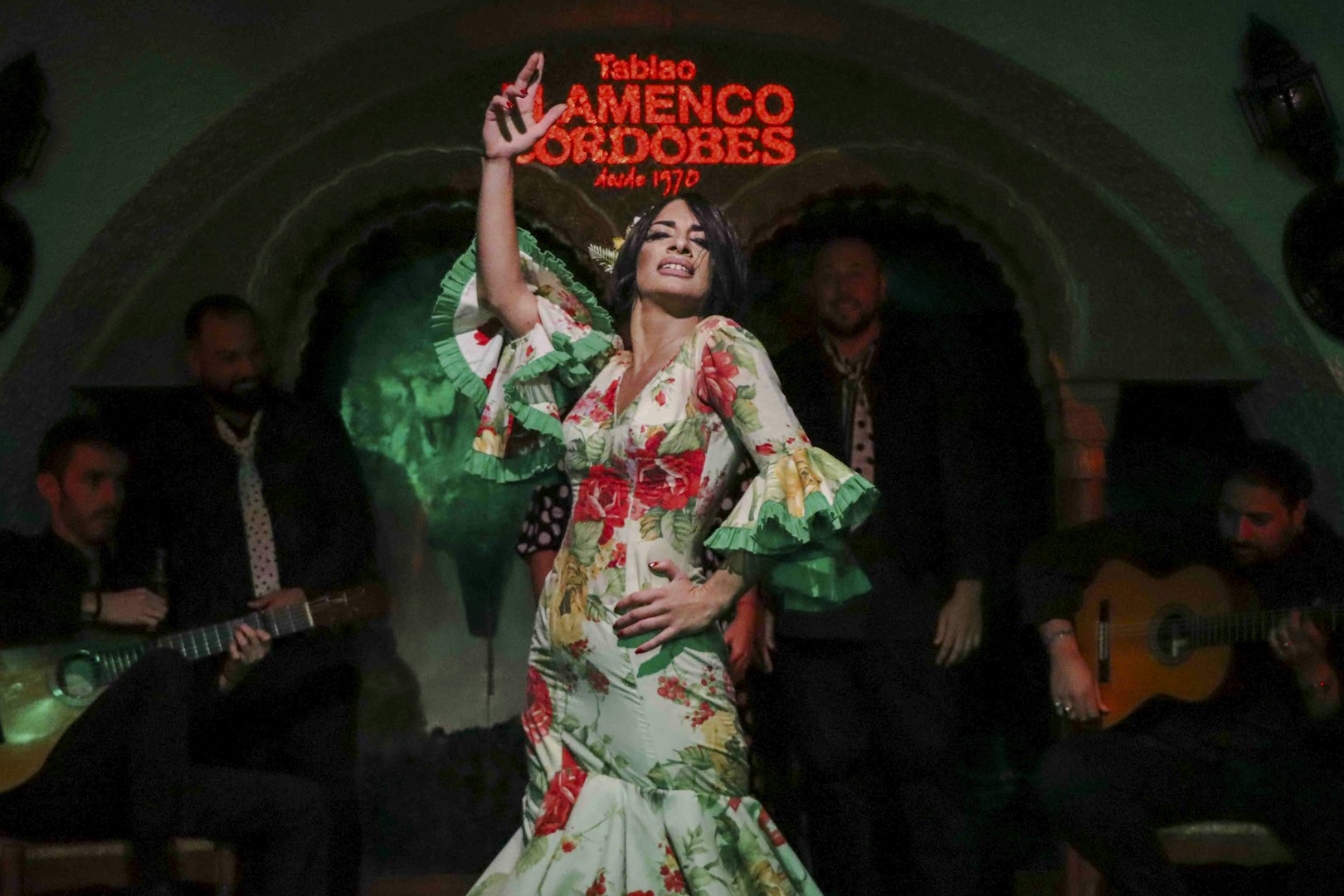 Flamenco dancer performing at Tablao Cordobes with musicians in the background.