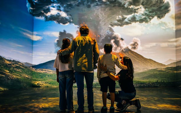 Family observing Mount Vesuvius eruption exhibit, Los últimos días de Pompeya tour.