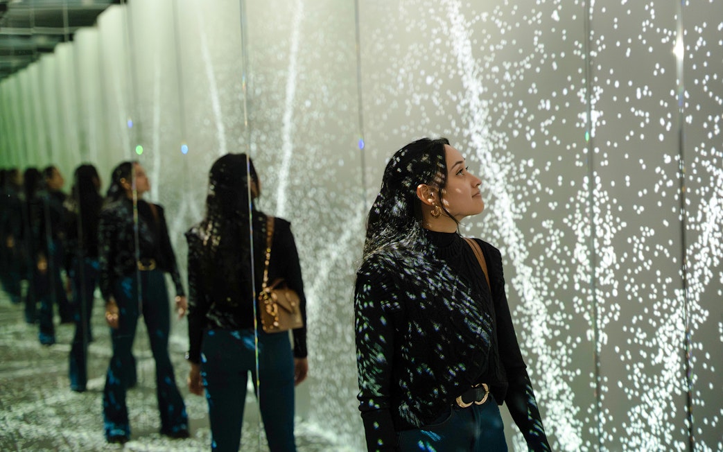 Guest exploring mirrored light display at World of Illusion, Dublin.